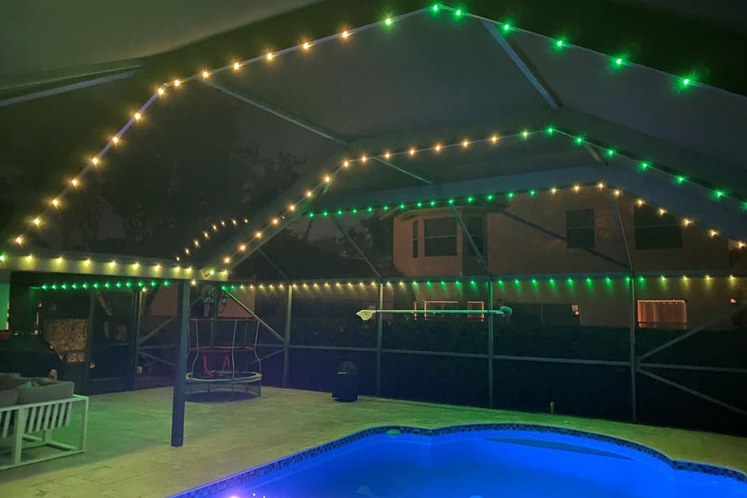 A screened pool enclosure with clean white lighting tracing its frame.