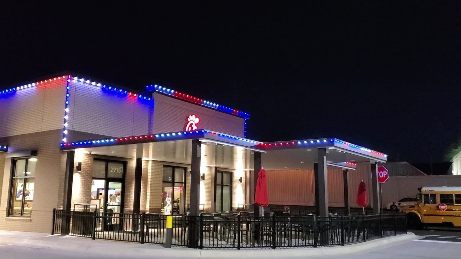 A commercial building outlined in LED lighting at night.